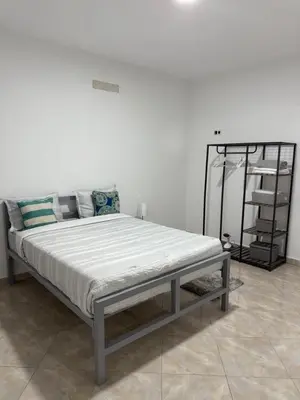 a bed in a room with a white wall at Casa Cucuia in Praia