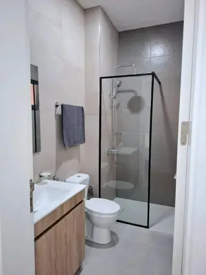 a bathroom with a shower and a toilet and a sink at R3 Apartments - Laginha in Mindelo