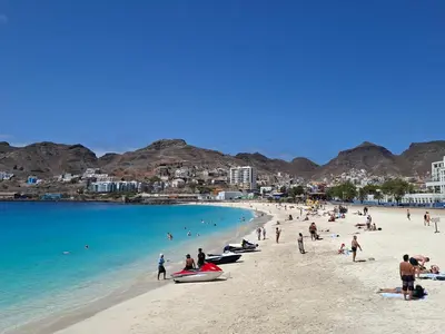 a group of people on a beach near the water at R3 Apartments - Laginha in Mindelo