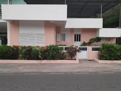 a pink house with white doors on a street at NoS Casa in Montanha