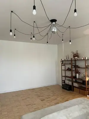 a room with a white wall and a chandelier at Apt Martins May 2 in Vila do Maio