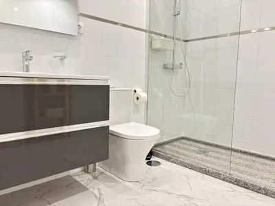 a white bathroom with a toilet and a shower at Relax and Stay in Praia Spacious 3bdr Apartment in Praia