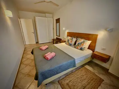 a bedroom with a large bed with two pink pillows at Salty Soul Ac Wifi in Santa Maria