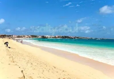 a beach with people walking on the sand and the ocean at Salty Soul Ac Wifi in Santa Maria