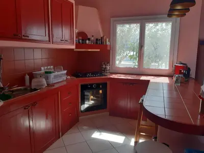 a kitchen with red cabinets and a stove top oven at Dolphin Cabo Verde in Tarrafal