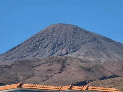 a mountain with a building in front of it at Dolphin Cabo Verde in Tarrafal