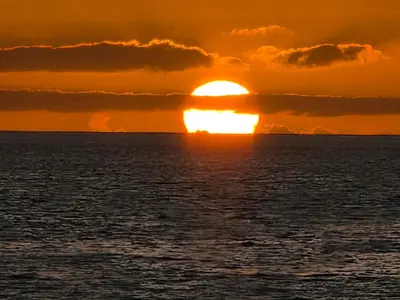 a sunset over the ocean with the sun setting at Dolphin Cabo Verde in Tarrafal