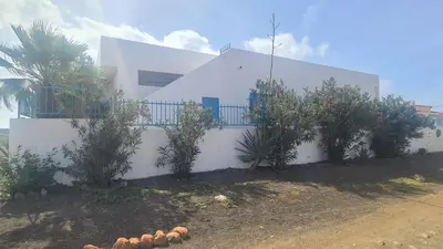 a white house with plants in front of it at Dolphin Cabo Verde in Tarrafal