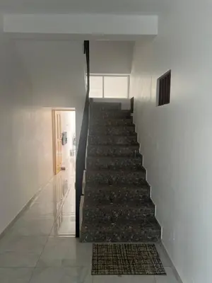 a staircase in a white building with a rug at Casa Ida 2 Tarrafal, Santiago, Cape verde in Tarrafal