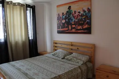 a bedroom with a bed and a painting on the wall at Paradise in Praia