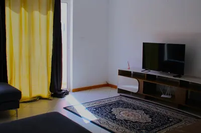 a living room with a flat screen tv on a entertainment center at Paradise in Praia