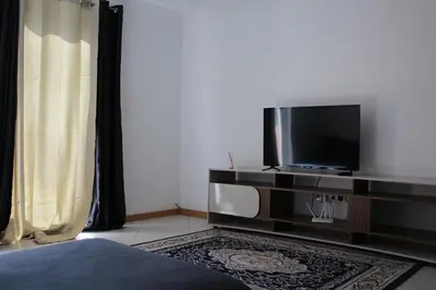 a living room with a television and a bed at Paradise in Praia