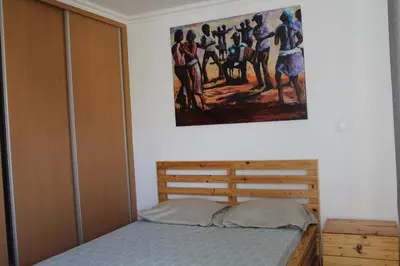 a bedroom with a bed and a painting on the wall at PR T2 TerceiroB in Praia
