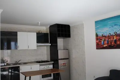 a kitchen with white cabinets and a painting on the wall at PR T2 TerceiroB in Praia
