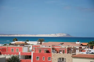 a city with red buildings and the ocean at Beautiful Penthouse in Sal Rei