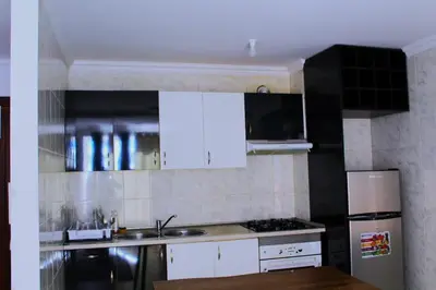 a kitchen with white cabinets and a stainless steel refrigerator at PR T1 TerceiroB in Praia