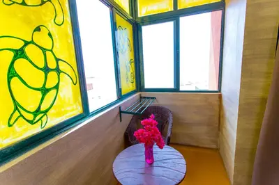 a vase of flowers sitting on a table in a room with windows at Surfactivity Guest House in Santa Maria
