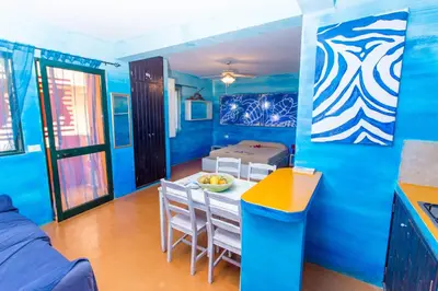 a blue room with a table and chairs and a bed at Surfactivity Guest House in Santa Maria