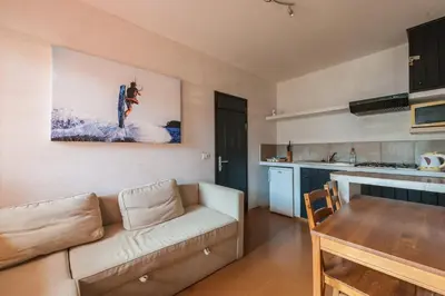 a living room with a couch and a table and a kitchen at Surfactivity Guest House in Santa Maria