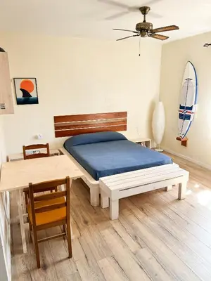a bedroom with a bed and a table and chairs at Surfactivity Guest House in Santa Maria