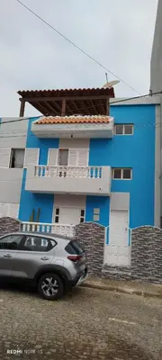 a car parked in front of a blue building at Residencial Soares in Espargos