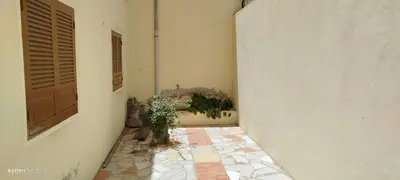 a hallway with a door and a plant on the floor at Residencial Soares in Espargos