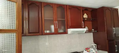a kitchen with wooden cabinets and a microwave at Residencial Soares in Espargos