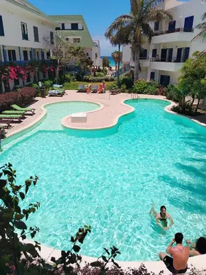 a group of people in a swimming pool at a resort at Leme Bedje Residence in Santa Maria