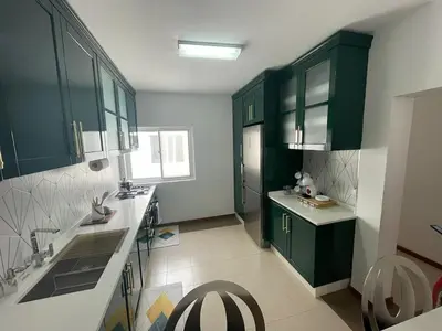 a kitchen with green cabinets and a white counter top at Our Happy Place Prainha in Praia