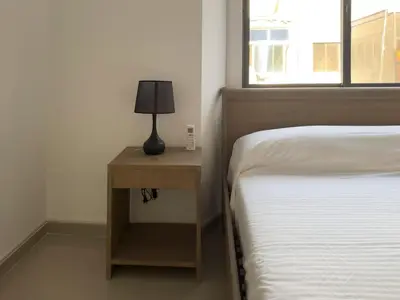 a bedroom with a bed and a nightstand with a lamp at Spacious 2 bdr apt in Achada St Antonio - LCGR in Praia