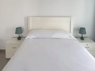 a bedroom with a large white bed with two lamps at Spacious 2 bdr apt in Achada St Antonio - LCGR in Praia