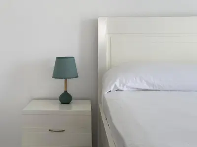 a bedroom with a bed and a lamp on a nightstand at Spacious 2 bdr apt in Achada St Antonio - LCGR in Praia