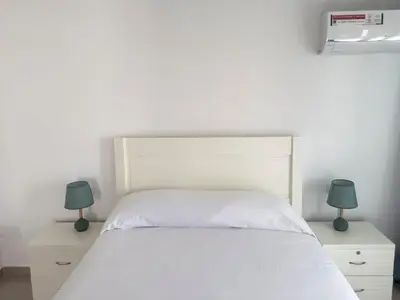 a bedroom with a white bed with two lamps at Spacious 2 bdr apt in Achada St Antonio - LCGR in Praia