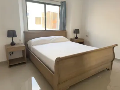 a bedroom with a bed with two nightstands and a window at Spacious 2 bdr apt in Achada St Antonio - LCGR in Praia