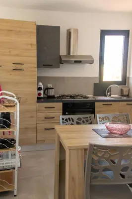 a kitchen with wooden cabinets and a table and a stove at Atlantic Sal Ocean View in Santa Maria