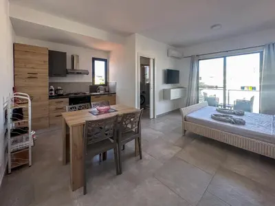 a kitchen and living room with a table and a bed at Atlantic Sal Ocean View in Santa Maria