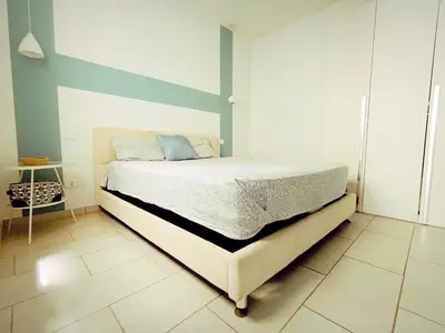 a bedroom with a bed with a blue accent wall at Boadream Casa Duria Porta Viola in Prainha