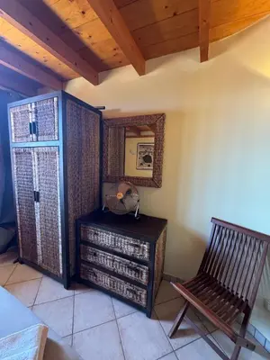a room with a chair and a table and a window at Holiday Properties Prestige Apartments in Santa Maria