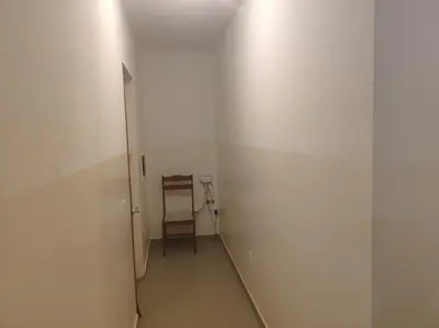 a hallway with a chair in a white room at Kaza Horta in Tarrafal