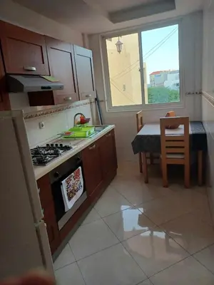 a kitchen with a stove and a table and a window at Imperio in Praia