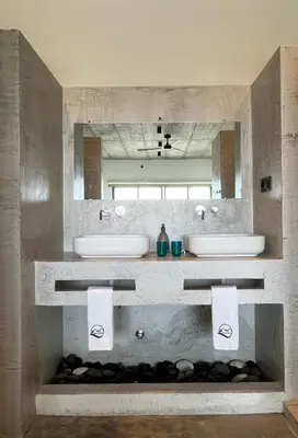a bathroom with two sinks and two mirrors at Boutique Hotel Luz da Lua in Ponta do Sol