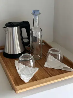 a wooden tray with a bottle and two glasses on it at Boutique Hotel Luz da Lua in Ponta do Sol