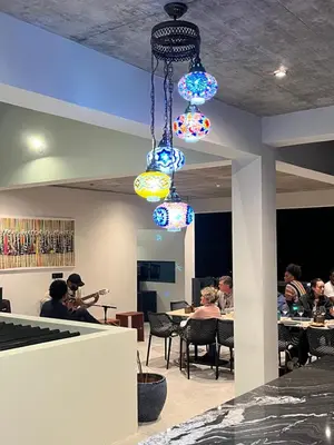a group of people sitting at tables in a restaurant at Boutique Hotel Luz da Lua in Ponta do Sol