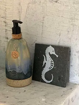 a bottle and a box with a seahorse painted on it at Boutique Hotel Luz da Lua in Ponta do Sol