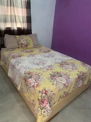 a bed with a floral comforter on top of it at Pousada casa Eurico in Portela