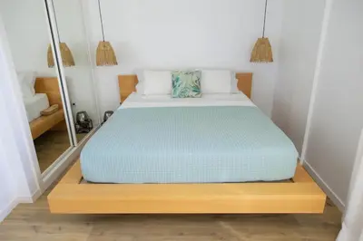 a bed in a small room with a mirror at Helena - Marel Bliss Apartments T3 in Mindelo