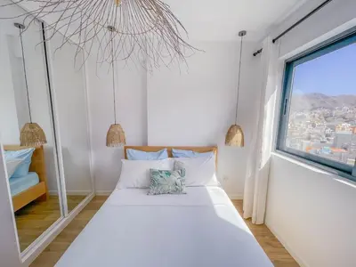 a bedroom with a bed and a large window at Helena - Marel Bliss Apartments T3 in Mindelo
