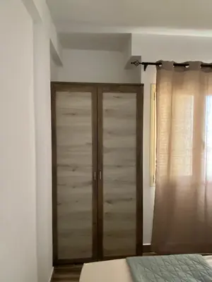 a bedroom with a closet with wooden doors at MaRiRa Apartments T1 in Santa Maria