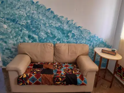 a couch in a room with a blue wall at Kasa Sirena in Tarrafal