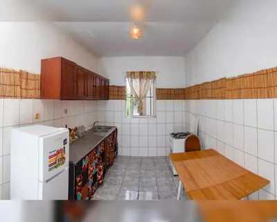 a kitchen with a refrigerator and a table in it at Kasa Sirena in Tarrafal